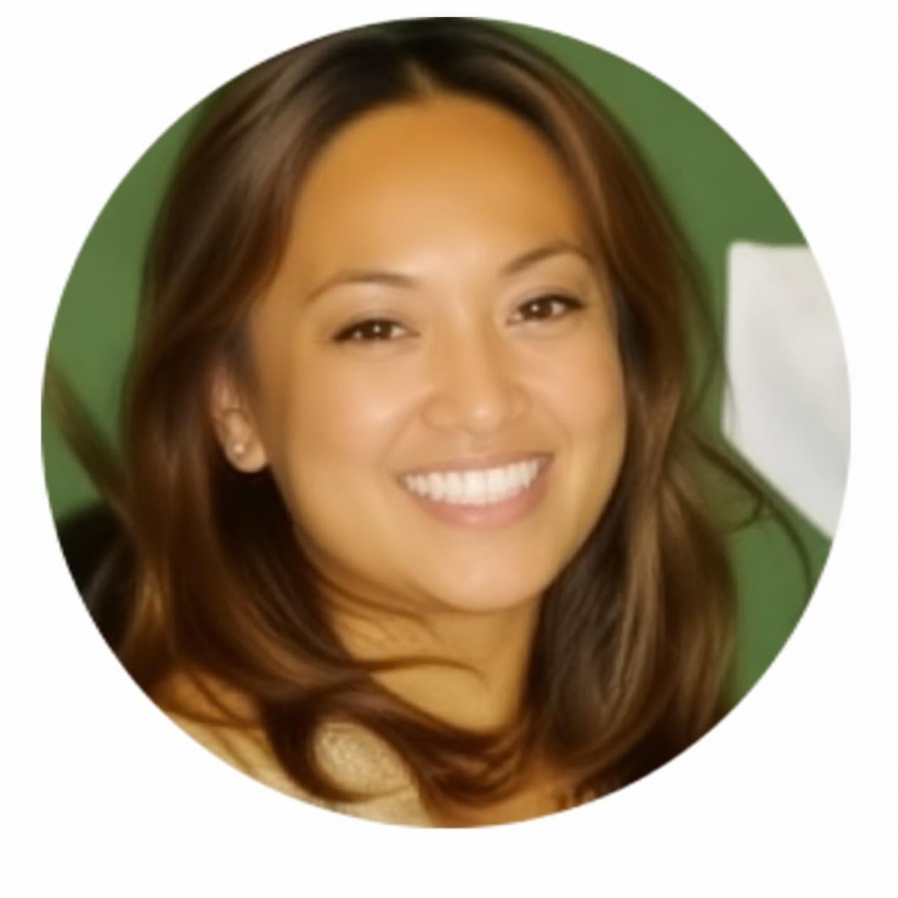 Smiling woman with long brown hair in a circular headshot against a blurred green background.